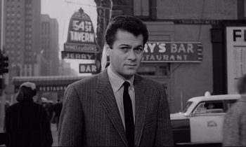 Movie still from “Sweet Smell of Success” (1957), directed by Alexander Mackendrick – Black and white photograph of a man wearing a suit and tie; Medium shot, Low angle