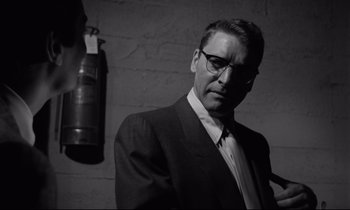 Movie still from “Sweet Smell of Success” (1957), directed by Alexander Mackendrick – Black and white photograph of a man wearing a suit and tie; Close Up shot, Low angle