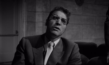 Movie still from “Sweet Smell of Success” (1957), directed by Alexander Mackendrick – Black and white photograph of a man in a suit and tie; Close Up shot, Low angle