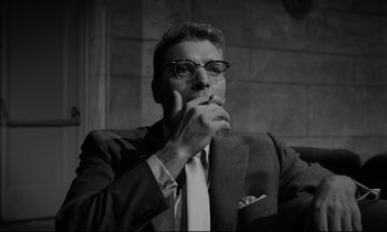Movie still from “Sweet Smell of Success” (1957), directed by Alexander Mackendrick – Black and white photograph of a man smoking a cigarette; Close Up shot, Low angle