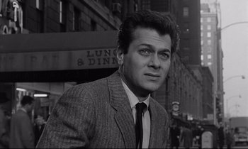 Movie still from “Sweet Smell of Success” (1957), directed by Alexander Mackendrick – Black and white photograph of a man wearing a suit and tie; Close Up shot, Low angle
