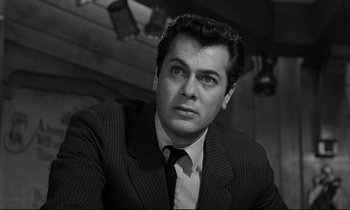 Movie still from “Sweet Smell of Success” (1957), directed by Alexander Mackendrick – Black and white photograph of a man wearing a suit; Close Up shot, Low angle