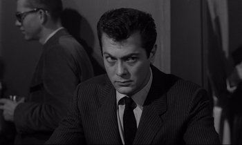 Movie still from “Sweet Smell of Success” (1957), directed by Alexander Mackendrick – Black and white photograph of a man wearing a suit and tie; Close Up shot, Low angle