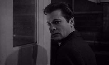 Movie still from “Sweet Smell of Success” (1957), directed by Alexander Mackendrick – A black - and - white photo of a man leaning against a wall; Close Up shot, Low angle