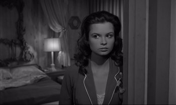 Movie still from “Sweet Smell of Success” (1957), directed by Alexander Mackendrick – A black - and - white photo of a woman standing in front of a bed; Close Up shot, High angle