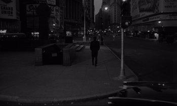 Movie still from “Sweet Smell of Success” (1957), directed by Alexander Mackendrick – A man walking down a street at night; Extreme Wide shot, High angle