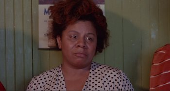 Movie still from “Sweet Sweetback's Baadasssss Song” (1971), directed by Melvin Van Peebles – A person wearing a polka dot shirt; Close Up shot, Over the shoulder angle