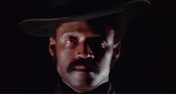 Movie still from “Sweet Sweetback's Baadasssss Song” (1971), directed by Melvin Van Peebles – A person wearing a hat; Close Up shot, Low angle
