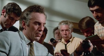 Movie still from “Sweet Sweetback's Baadasssss Song” (1971), directed by Melvin Van Peebles – A group of men standing next to each other in a room; Medium shot, Low angle