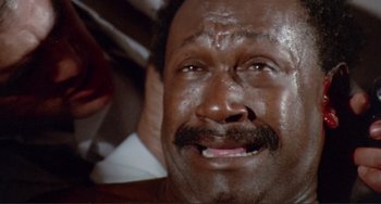 Movie still from “Sweet Sweetback's Baadasssss Song” (1971), directed by Melvin Van Peebles – A person with a beard and mustache; Extreme Close Up shot, High angle