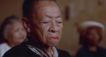 Movie still from “Sweet Sweetback's Baadasssss Song” (1971), directed by Melvin Van Peebles – An older woman with a sad look on her face; Close Up shot, Low angle