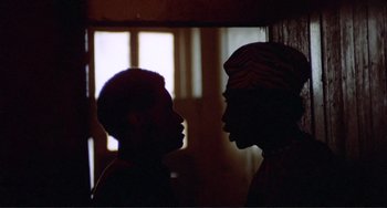 Movie still from “Sweet Sweetback's Baadasssss Song” (1971), directed by Melvin Van Peebles – Two people are facing each other in a room; Close Up shot, Low angle