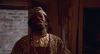 Movie still from “Sweet Sweetback's Baadasssss Song” (1971), directed by Melvin Van Peebles – A man in a leopard print jacket and a gold necklace; Close Up shot, Low angle