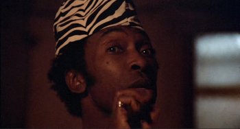 Movie still from “Sweet Sweetback's Baadasssss Song” (1971), directed by Melvin Van Peebles – A person wearing a hat; Close Up shot, Low angle