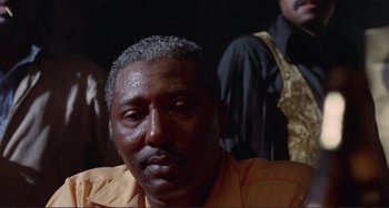 Movie still from “Sweet Sweetback's Baadasssss Song” (1971), directed by Melvin Van Peebles – A person wearing an orange shirt; Close Up shot, Low angle