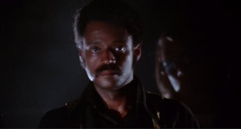 Movie still from “Sweet Sweetback's Baadasssss Song” (1971), directed by Melvin Van Peebles – A person with a beard and mustache; Close Up shot, Low angle