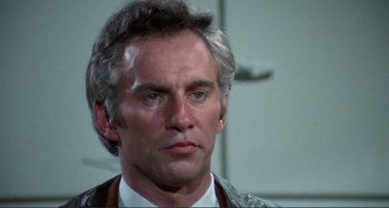 Movie still from “Sweet Sweetback's Baadasssss Song” (1971), directed by Melvin Van Peebles – An older man in a white shirt and a gray jacket; Close Up shot, Low angle