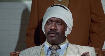 Movie still from “Sweet Sweetback's Baadasssss Song” (1971), directed by Melvin Van Peebles – A man with a bandage on his head; Close Up shot, High angle