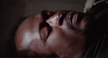 Movie still from “Sweet Sweetback's Baadasssss Song” (1971), directed by Melvin Van Peebles – A man's face with his eyes closed; Close Up shot, High angle