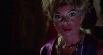 Movie still from “Sweet Sweetback's Baadasssss Song” (1971), directed by Melvin Van Peebles – A person with makeup on; Close Up shot, Over the shoulder angle