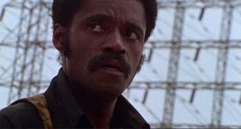 Movie still from “Sweet Sweetback's Baadasssss Song” (1971), directed by Melvin Van Peebles – A person with a beard and mustache; Close Up shot, Low angle