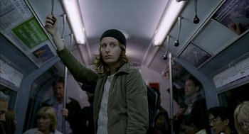 Movie still from “Swimming Pool” (2003), directed by François Ozon – A man standing on a crowded subway train; Medium shot, Low angle