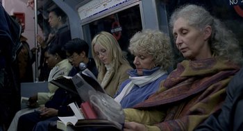 Movie still from “Swimming Pool” (2003), directed by François Ozon – A group of people sitting on a train reading books; Medium shot, High angle