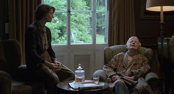 Movie still from “Swimming Pool” (2003), directed by François Ozon – Two people are sitting in a living room; Medium shot, Over the shoulder angle
