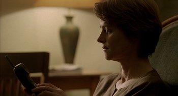 Movie still from “Swimming Pool” (2003), directed by François Ozon – A woman sitting in front of a green vase looking off into the distance; Close Up shot, Low angle