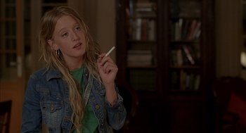 Movie still from “Swimming Pool” (2003), directed by François Ozon – A young woman holding a cigarette in her hand; Close Up shot, Over the shoulder angle