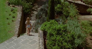 Movie still from “Swimming Pool” (2003), directed by François Ozon – A little girl walking down the stairs in a garden; Extreme Wide shot, High angle
