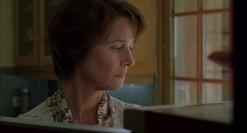 Movie still from “Swimming Pool” (2003), directed by François Ozon – A person sitting at a table; Close Up shot, Low angle