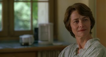 Movie still from “Swimming Pool” (2003), directed by François Ozon – A person sitting in front of a window; Close Up shot, Over the shoulder angle