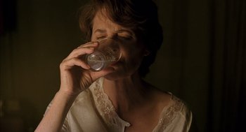 Movie still from “Swimming Pool” (2003), directed by François Ozon – A woman drinking a glass of water from a cup; Close Up shot, High angle