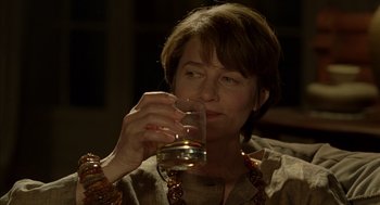 Movie still from “Swimming Pool” (2003), directed by François Ozon – A woman holding a wine glass in her hand; Close Up shot, Over the shoulder angle