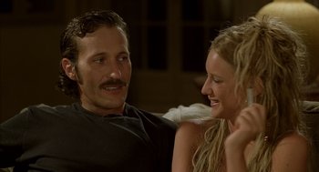 Movie still from “Swimming Pool” (2003), directed by François Ozon – A man and a woman sitting next to each other on a couch; Close Up shot, Over the shoulder angle