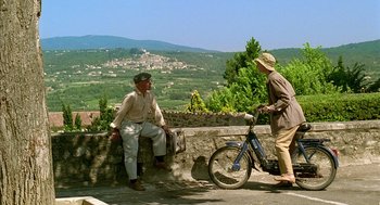 Movie still from “Swimming Pool” (2003), directed by François Ozon – Two older men are talking on the side of the road; Wide shot, Low angle