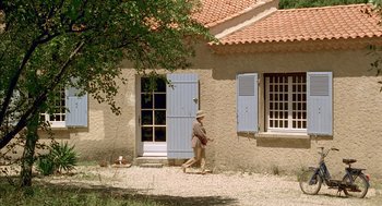 Movie still from “Swimming Pool” (2003), directed by François Ozon – An old man walking in front of a house; Extreme Wide shot, High angle