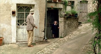 Movie still from “Swimming Pool” (2003), directed by François Ozon – A man and a woman standing in front of a door; Wide shot, High angle