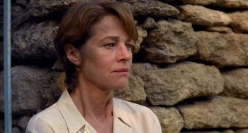 Movie still from “Swimming Pool” (2003), directed by François Ozon – A person wearing a white shirt near a stone wall; Close Up shot, Low angle