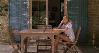 Movie still from “Swimming Pool” (2003), directed by François Ozon – A woman sitting at a table with a bowl of food; Wide shot, High angle