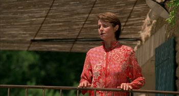 Movie still from “Swimming Pool” (2003), directed by François Ozon – A woman in a red shirt standing next to a railing; Medium shot, Low angle
