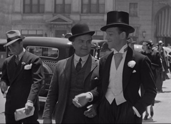 Movie still from “Swing Time” (1936), directed by George Stevens – Two men in top hats and suits walk down the street; Medium shot, Low angle
