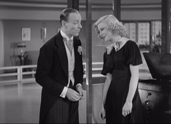 Movie still from “Swing Time” (1936), directed by George Stevens – A man and a woman standing next to each other; Medium shot, High angle