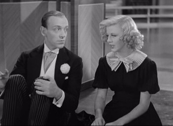 Movie still from “Swing Time” (1936), directed by George Stevens – A man and a woman are standing next to each other; Medium shot, High angle