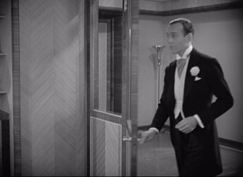 Movie still from “Swing Time” (1936), directed by George Stevens – A black and white photo of a man in a tuxedo; Medium shot, High angle