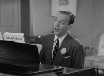 Movie still from “Swing Time” (1936), directed by George Stevens – A man in a suit and tie sitting at a piano; Medium shot, High angle