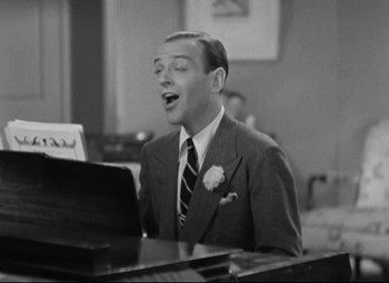 Movie still from “Swing Time” (1936), directed by George Stevens – A black - and - white photo of a man in a suit singing; Medium shot, Low angle