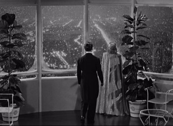 Movie still from “Swing Time” (1936), directed by George Stevens – A man and a woman looking out of a window at a city; Extreme Wide shot, High angle
