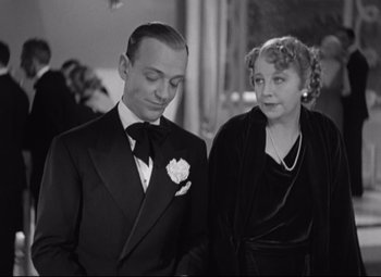 Movie still from “Swing Time” (1936), directed by George Stevens – A man and a woman standing next to each other; Medium shot, High angle